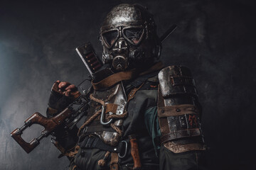 Fototapeta premium Survivor with custom armour and gun poses in dark background