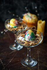 A painted egg lies in a glass with a mixture of seeds and cereals, a symbol of abundance, an Easter composition