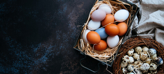 Vintage background with Easter eggs. Vintage kitchenware on dark background. Easter background with eggs and spring branches.Top view with copy space.