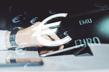 Creative EURO symbols sketch and hand working with a digital tablet on background, strategy and forecast concept. Multiexposure