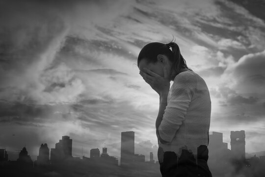 Woman standing in the city with hand over face feeling sad and crying