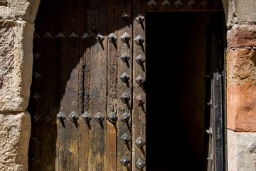 
Puerta antigua de madera adornada con clavos en la entrada de una casa solariega en Sigüenza, España
