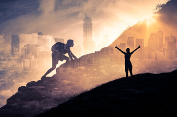 Silhouette of a person climbing to the top of a mountain. Female with arms up to the sky. Strong...