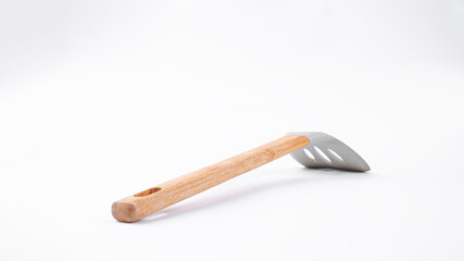 Kitchen spatula with wooden handle on a white background. Side view of kitchen spatula.