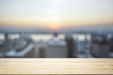 Fototapeta na wymiar Empty wooden tabletop with beautiful blurry skyscrapers in the afternoon on background, mock up