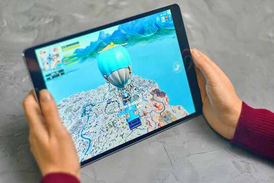 Bishkek, Kyrgyzstan - January 21, 2019: Woman playing fortnite game of epic games company on Apple ios tablet iPad Pro. Gameplay Action