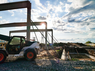 Obraz premium excavator on new construction site, in the background the blue sky and sun