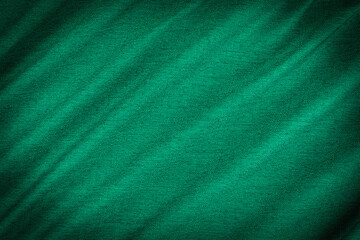 green background of fabric from a piece of crumpled clothes.