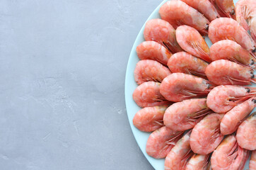  Fresh boiled shrimp in blue dish on a gray cement background with copy space.Top view.