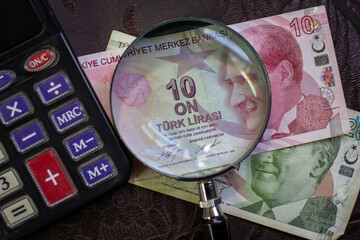 Turkish lira bills seen through a magnifying glass and a calculator