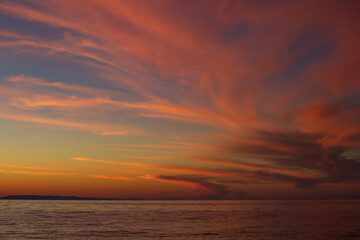 Fototapeta na wymiar Dramatic red clouds after sunset in dusk on Lake Baikal, beautiful scenic seascape, dark moody style