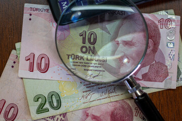 Turkish lira bills seen through a magnifying glass and a calculator