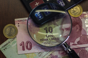 Turkish lira bills seen through a magnifying glass and coins