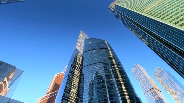 Beautiful bottom-up view of modern high-rise buildings of business centers against the background of blue skies on a clear day in the city