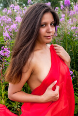 Attractive girl with red scarf on meadow