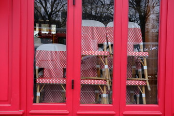 Fototapeta na wymiar Some chairs stacked at a closed parisian cafe due to the coronavirus pandemic. Paris march 2021.