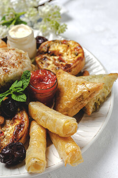 High angle of assorted tasty Arabic food with salsa and fresh mint leaves near almonds during Ramadan holidays