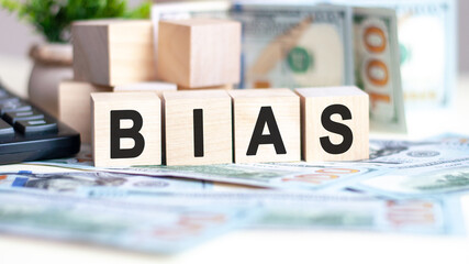 wooden blocks with text bias and banknotes on table, concept