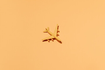 Top view of plastic toy airplane arranged on orange background