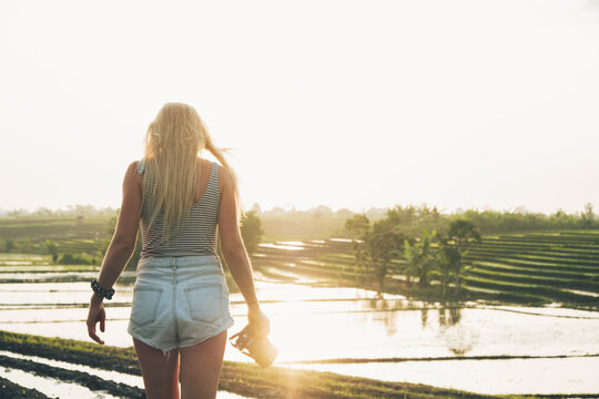 Blond woman taking photos in a rice field in Bali, Indonesia