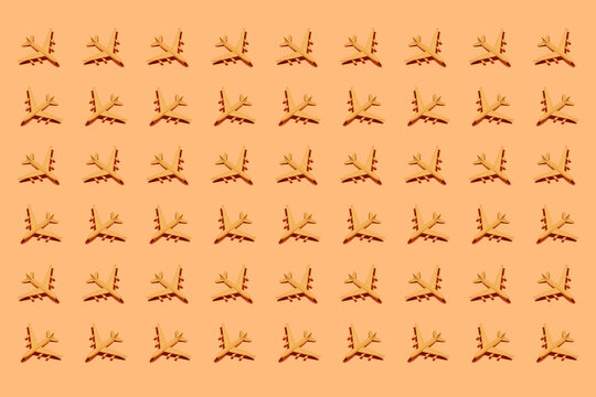 Top view of ornament of plastic toy airplanes arranged in rows on orange background