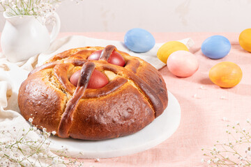 Portuguese traditional Easter cake. Folar with eggs on easter table. Blossom flowers and colorful...