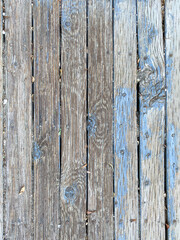 vertical wooden plank fence wood with faded weathered blue paint and rusty nails