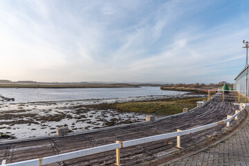 Obraz premium Irvine Harbour in Ayrshire Scotland looking over the Old Seaweed and Lichen Covered flats of the harbour to Ardeer in the far distance.