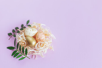 Easter background with eggs in a nest and green leaves.