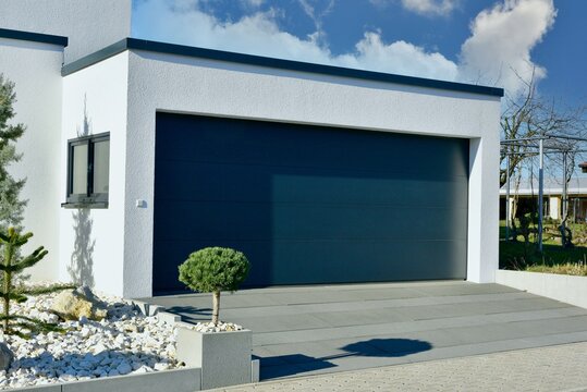 Moderne Beton-Garage mit Automatik-Tor in der Wohngeb&auml;ude-Zufahrt