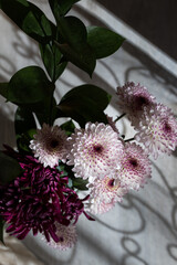 Closeup view of a bouquet of white and purple dahlias with harsh light environment.