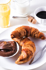 Croissant with chocolate hazelnut spread and cup of coffee