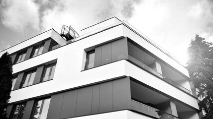 Part of city real estate property and condo architecture. Detail in modern residential flat apartment building exterior. Fragment of new luxury house. Black and white.