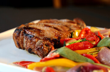 Ancho or Rib Eye. Steak on restaurant plate with colorful low carb vegetables