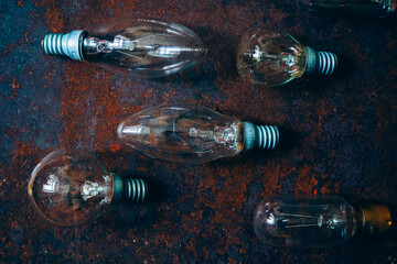 Incandescent light bulbs on rough metal surface, top view, background - 423079377
