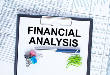 Text Financing Analysis on the folder that is located on the financial reports with calculator and stationery clips