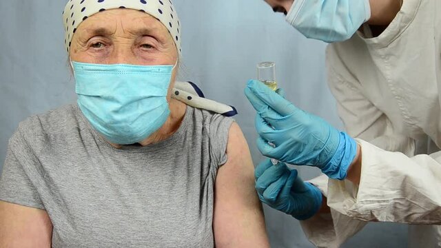 Vaccination Of The Elderly During The Coronavirus Pandemic. A Doctor Vaccinates An Old Grandmother During A Coronavirus Outbreak. An Elderly Woman Is Being Vaccinated Against Covid-19