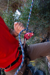 man climbing a mountain with rope