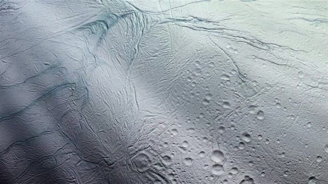 Surface of the Icy Moon Enceladus, Moon of Saturn, and Sun Rays. Elements of this Video furnished by NASA. 