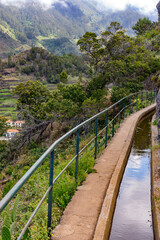 Fototapeta na wymiar Levada hiking trail secured with a railing in the mountains of Madeira