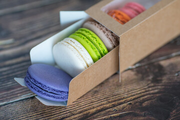 Close-up, macaroon cakes in paper box on dark background