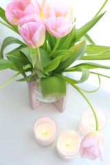 bouquet of tulips in vase with candles