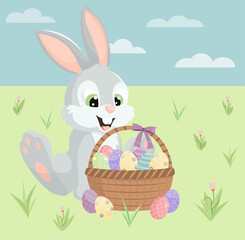 Easter rabbit sitting on the grass and a basket with eggs