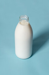 Milk bottle in pop art style on a blue background. Minimalism, vertical orientation