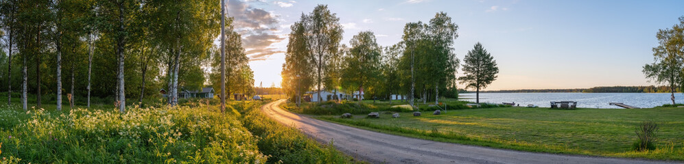 Scenic panorama of Swedish birch forest, summer village, lake and beautiful Sunset lighting on...