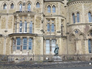 Fototapeta na wymiar Aberystwyth Old College Facade with Statue in Wales, UK