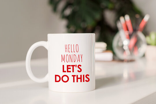 Coffee mug with text - Hello Monday, let's do this, in workplace background.