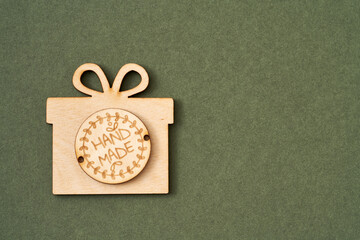Wooden Christmas present with inscription Handmade on green paper background with copy space