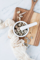 Gum resin in bowl with wooden board and marble background
