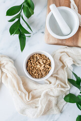 Dried licorice root in bowl with mortar and pestle 